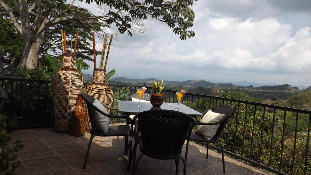 a table with chairs and vases on a balcony at Hotel Villas de la Colina in Atenas