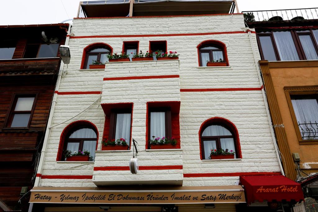 伊斯坦堡的住宿－亞拉臘酒店，白色的建筑,有红色的窗户和鲜花
