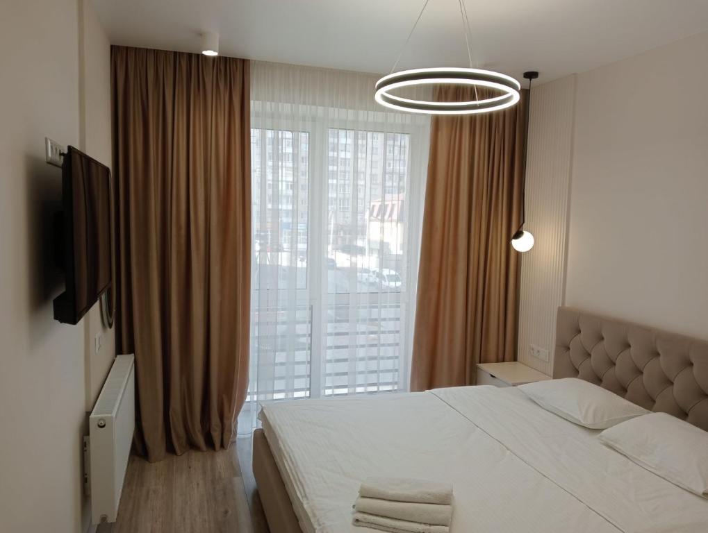 a bedroom with a bed and a large window at Люкс залізничний вокзал in Luts'k