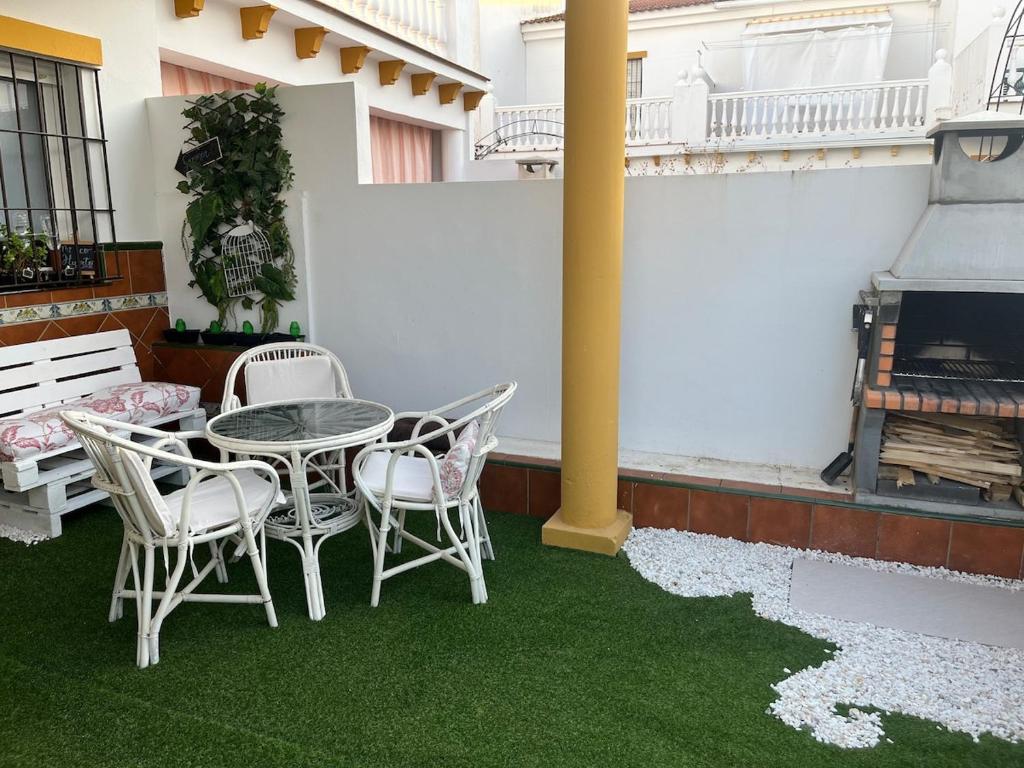 ウエルバにあるElSoldeLolaのパティオ(芝生の上にテーブルと椅子付)
