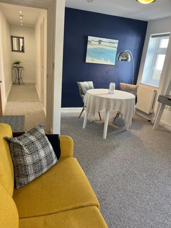a living room with a yellow couch and a table at Westerleigh Annexe - Self-contained accommodation in Langport