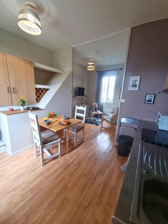une cuisine et un salon avec une table et des chaises dans l'établissement L'escale saint saint brévin les pins, à Saint-Brévin-les-Pins