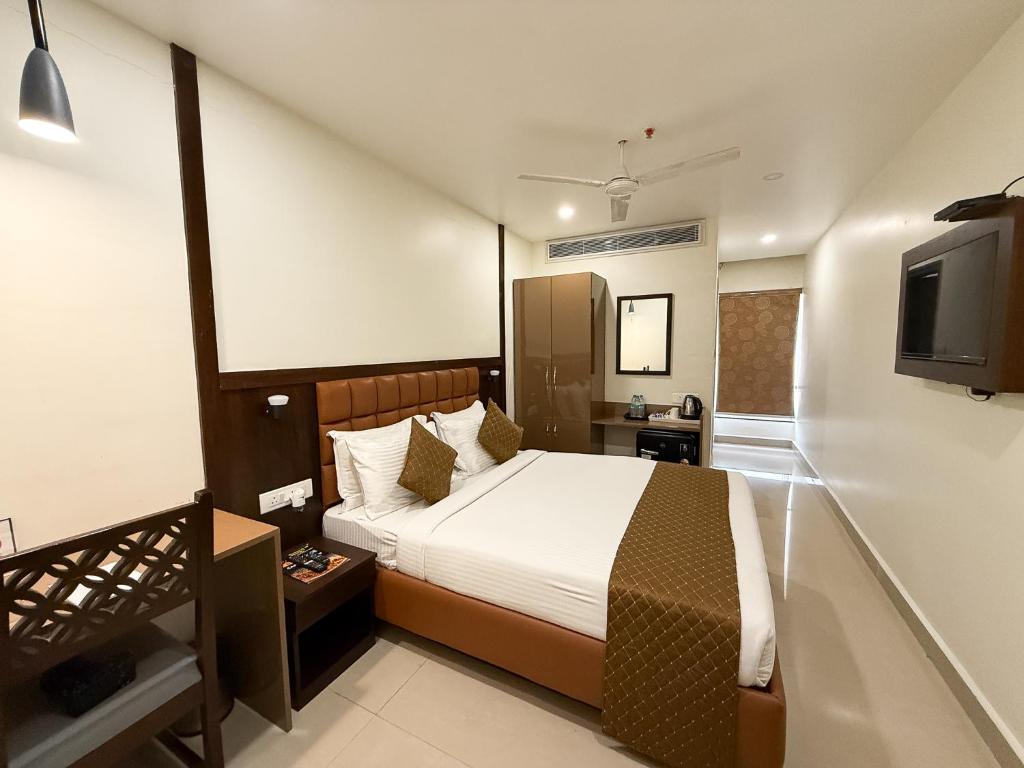 a bedroom with a bed and a flat screen tv at Hotel Landridge - HITECH City Hyderabad in Hyderabad
