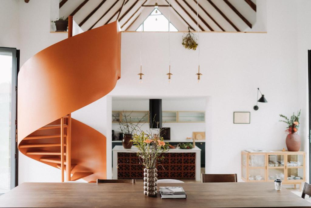 a dining room with a wooden table and a staircase at Porumbacu134 in Porumbacu de Sus