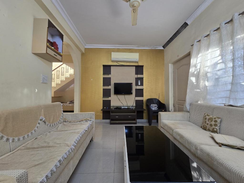 a living room with a couch and a tv at Blue Haven Villa - Luxurious 3BHK Stay in Jodhpur