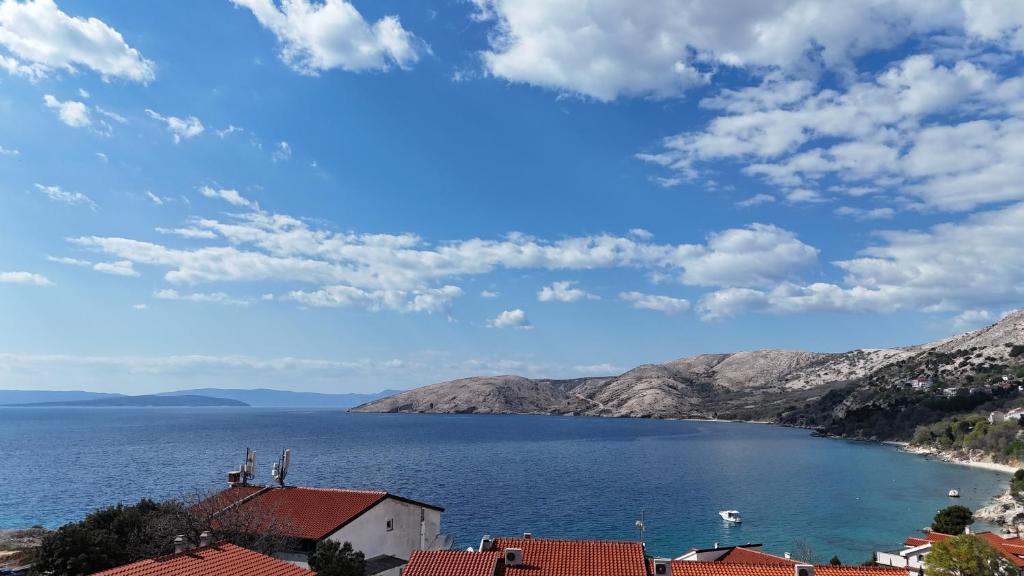a view of a large body of water with mountains at Eola Leisure Rooms in Stara Baška