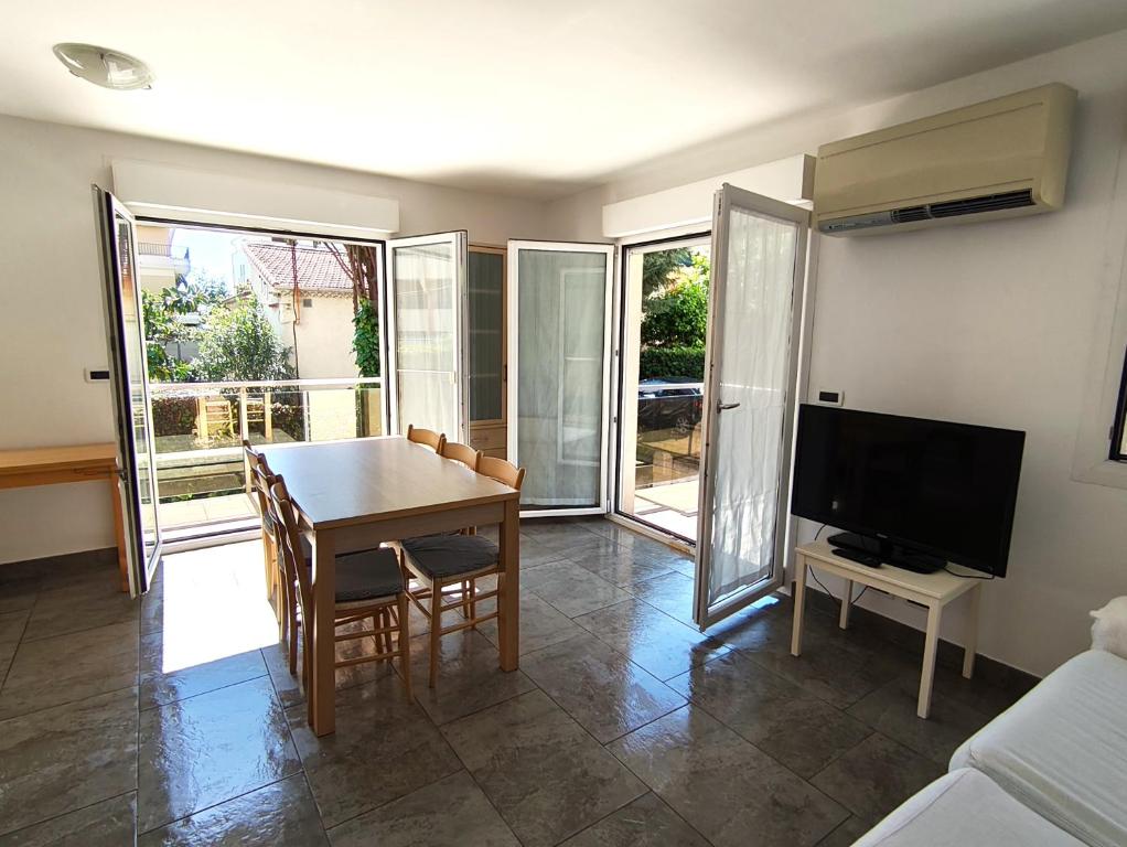 un salon avec une table et une télévision dans l'établissement Les Clementines, à Roquebrune-Cap-Martin