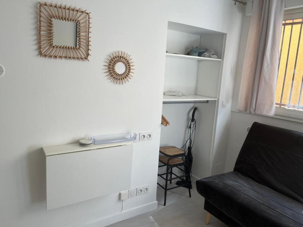 - un salon avec un canapé et un miroir mural dans l'établissement Studio Meublé Toulouse, à Toulouse