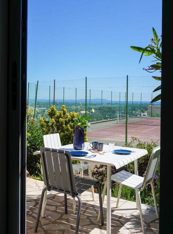 une table et des chaises avec vue sur l'océan dans l'établissement Le Soleil bleu Hyerois, à Hyères