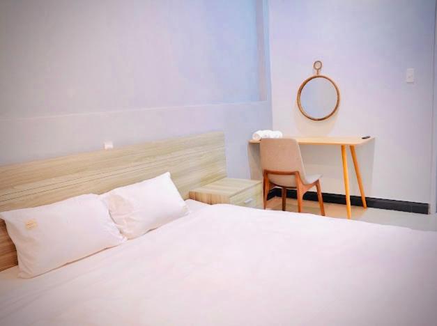 a bedroom with a bed and a desk with a mirror at LƯNG CHỪNG Home in Xuan An