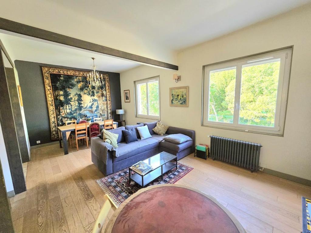 un salon avec un canapé et une table dans l'établissement COTTAGE : Charmante maison et jardin arboré en ville, à Montpellier