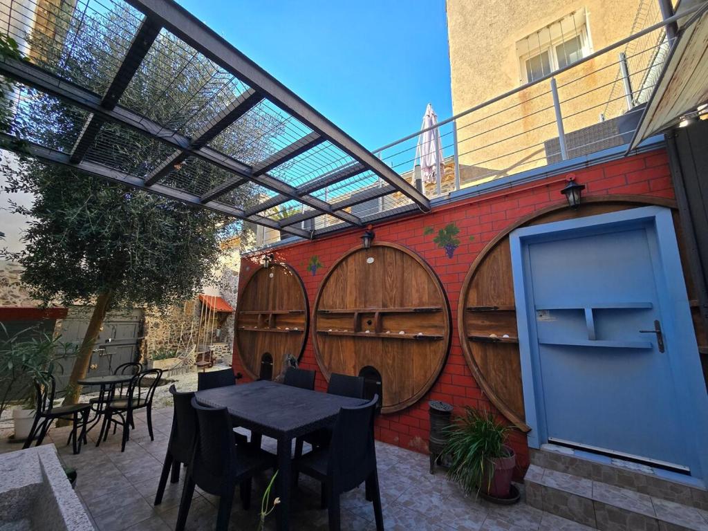 un patio avec une table et quelques tonneaux de vin en bois dans l'établissement CARNOT : Charmante maison Vigneronne en centre historique, à Agde
