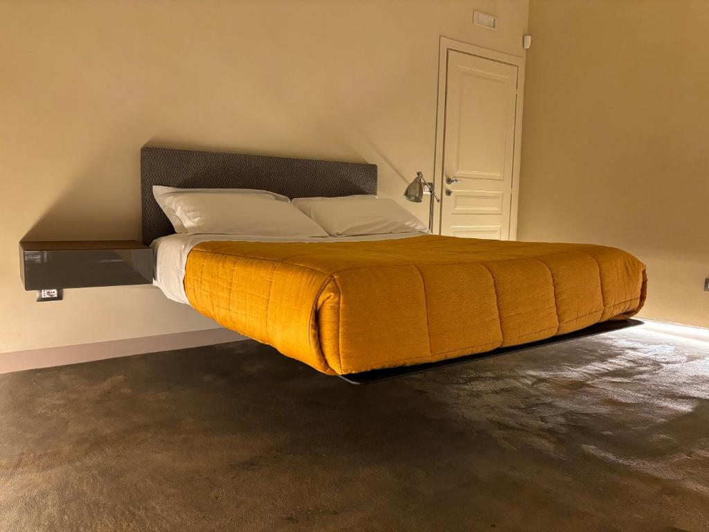 a bed with a yellow blanket on it in a room at Suite di Bianca in Foligno
