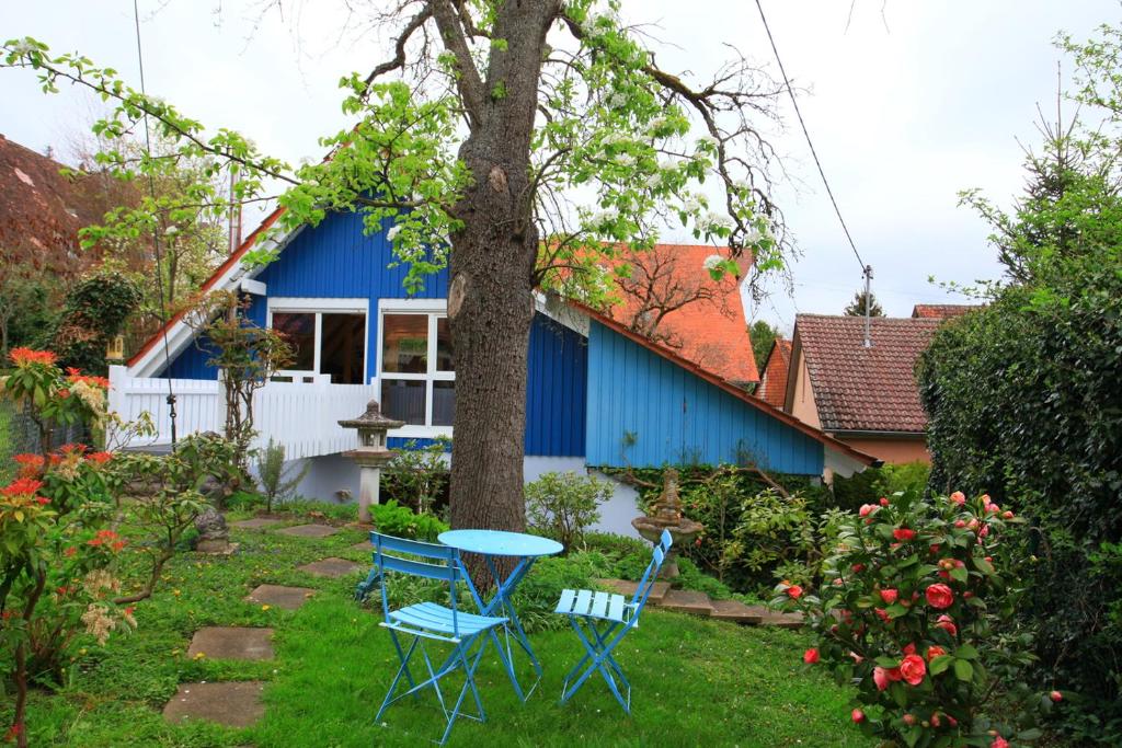 una casa azul con 2 sillas y una mesa en el patio en Das kleine Paradies, en Markdorf