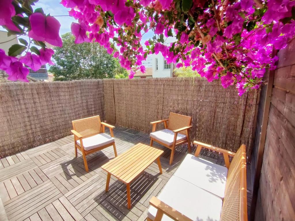 une terrasse avec 3 chaises et une table en bois dans l'établissement AZEMA : Cocon tranquille avec terrasse proche du centre, à Montpellier