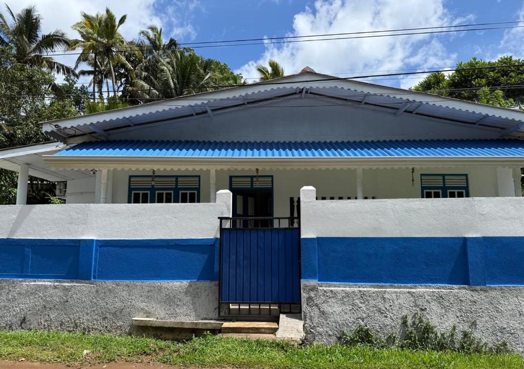 a house with blue and white walls and a gate at Liyaa Blue Beach Weligama in Weligama