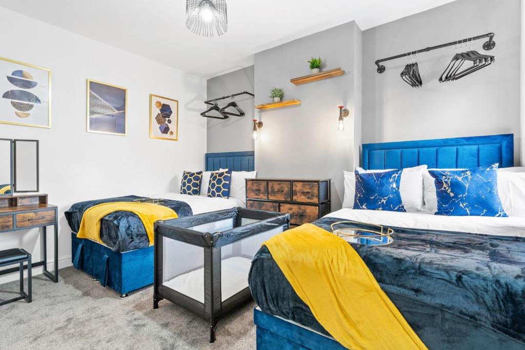 a bedroom with two beds and a desk at Stylish Birmingham Apartment For Groups, Family & Work in Birmingham