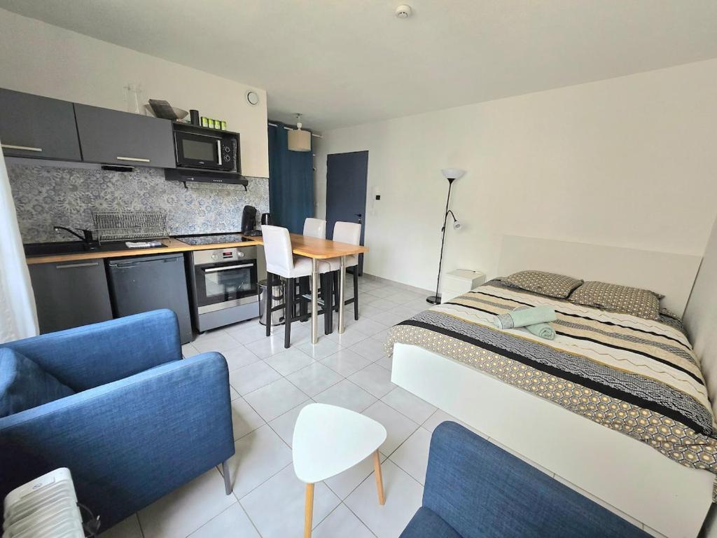 une chambre avec un lit et une cuisine avec une table dans l'établissement ACADIE : Studio quartier Antigone, ascenseur tramway calme, à Montpellier