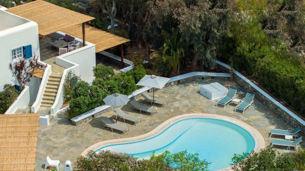 Una vista aérea de una piscina con sillas y sombrillas. en Villa Orea Beachfront by Mykonos Mood, en Kalafatis