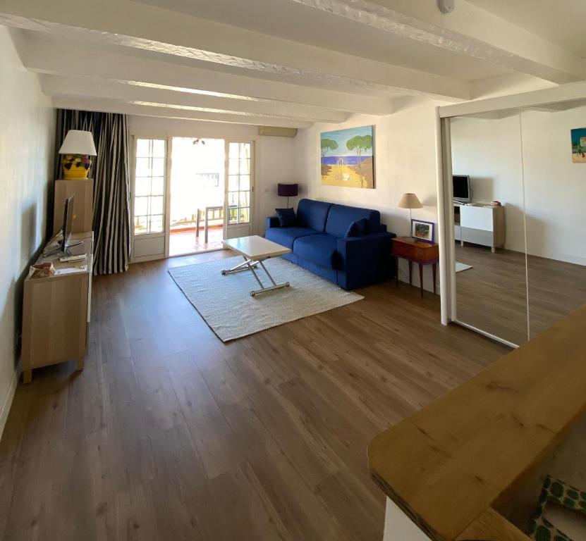 un salon avec un canapé bleu et une table dans l'établissement Emeraude, à Saint-Raphaël