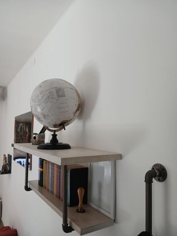 a globe sitting on a shelf with books at MUN Apartment City - Major Unforgettable Nights in Bergamo