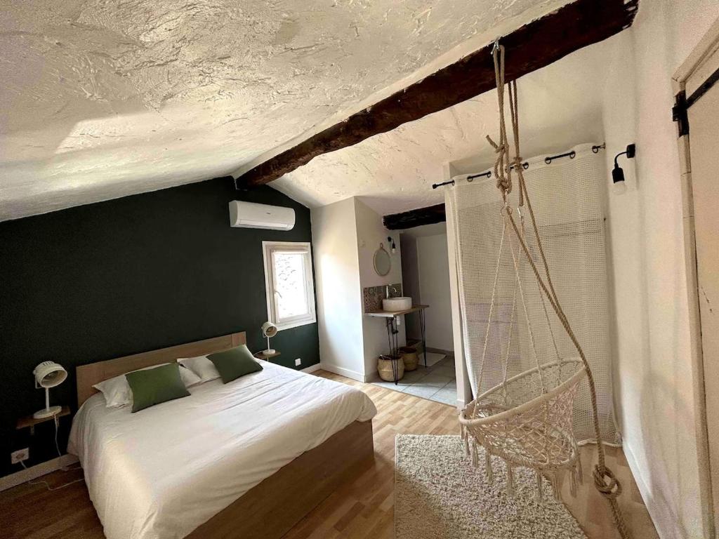 une chambre avec un lit blanc et une chaise dans l'établissement Appartement Duplex Lumineux au Centre de Grasse, à Grasse
