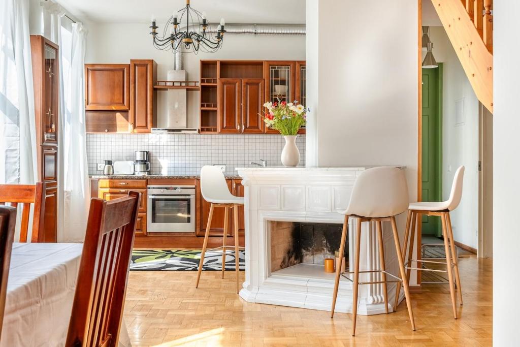 a kitchen with a fireplace and a table and chairs at Large and cozy 2-level apartment in Tallinn
