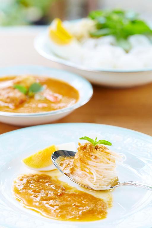 a plate of food on a table with a spoon at Uncle Loy's Boutique House in Bangkok