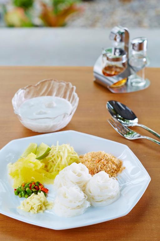 a white plate of food on a table at Uncle Loy's Boutique House in Bangkok