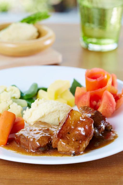 a plate of food with meat and vegetables on a table at Uncle Loy's Boutique House in Bangkok