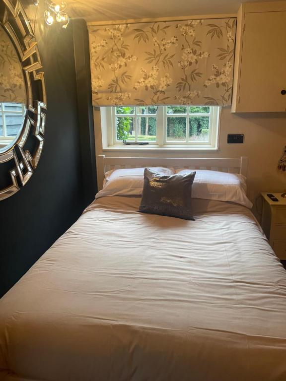 a bed in a bedroom with a window at Belle in Ugley