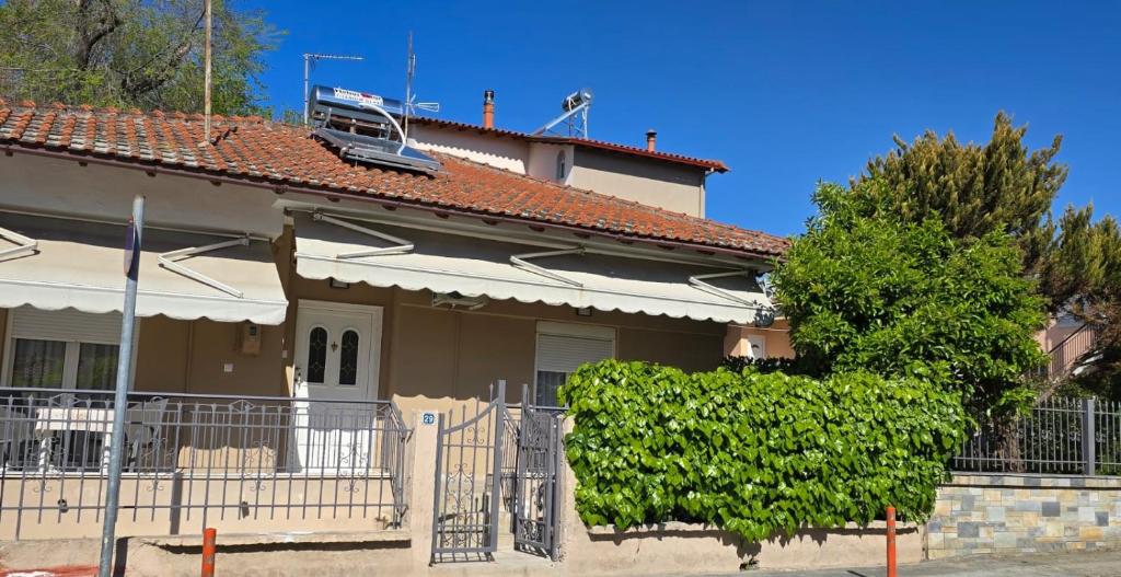a house with a fence and a tree at Lucky Apartment in Nea Kallikrateia