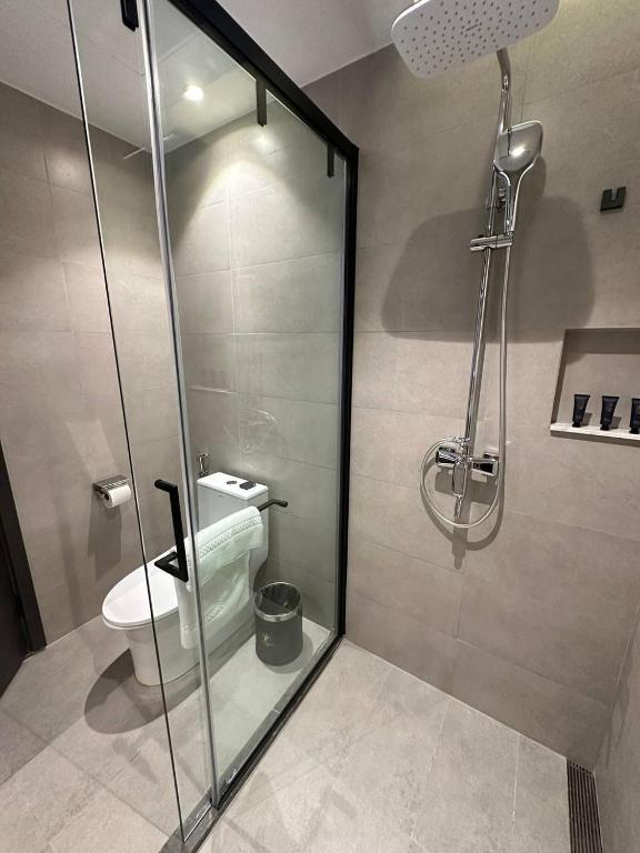 a bathroom with a shower and a toilet at 巴域永源酒店 in Phumĭ Bavĕt (2)