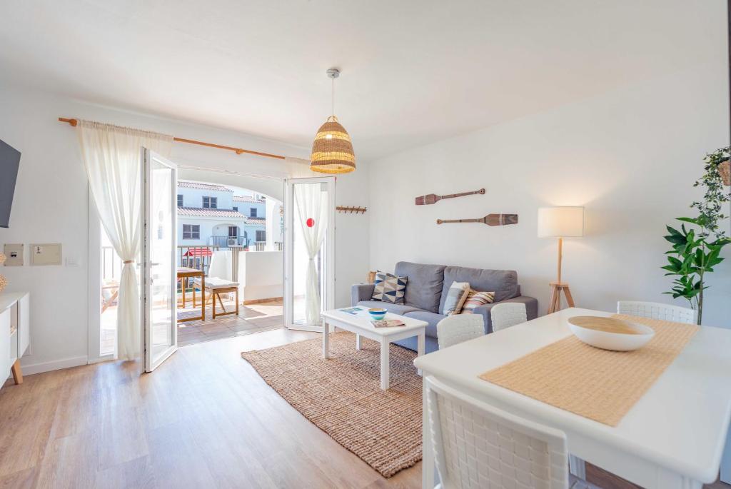 una sala de estar con un sofá y una mesa en Siesta Mar Chill Out, en Cala'n Porter