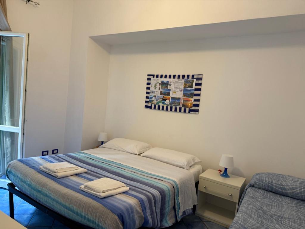 Postel nebo postele na pokoji v ubytování Ponzamania Appartamenti Ponza ,,Blumarine''
