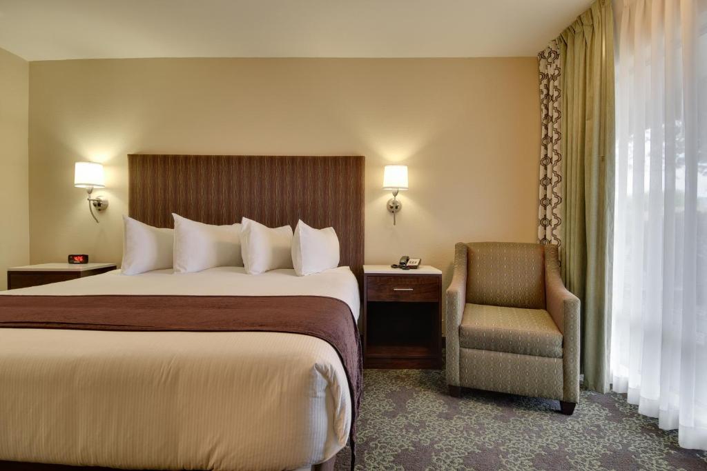 a hotel room with a bed and a chair at Vagabond Inn Bishop in Bishop