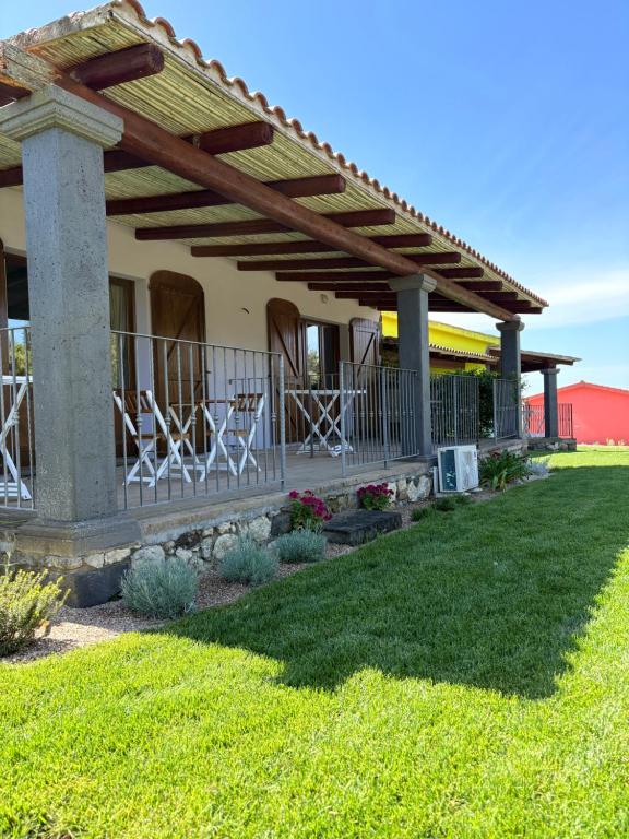patio z krzesłami pod pergolą w obiekcie Lugh'e Luna Village w mieście Narbolia