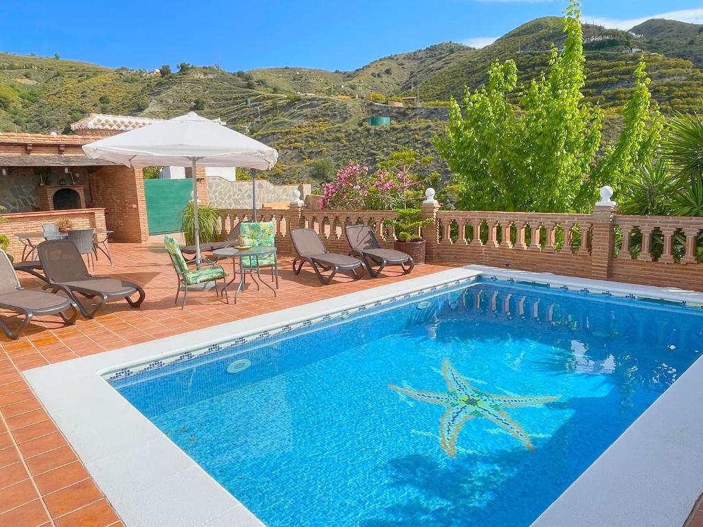 a swimming pool with chairs and a starfish in it at Villa Francisca in Málaga