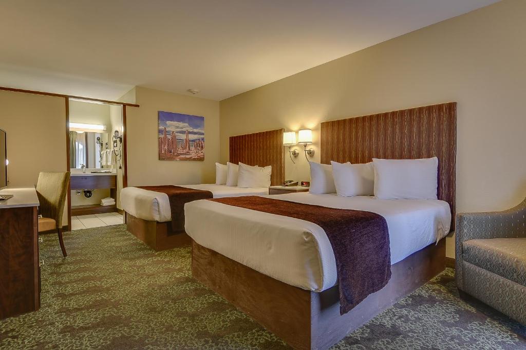 a hotel room with two beds and a couch at Vagabond Inn Bishop in Bishop