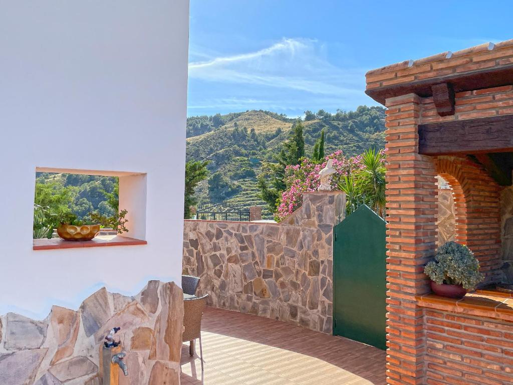a house with a stone wall and a patio at Villa Francisca in Málaga