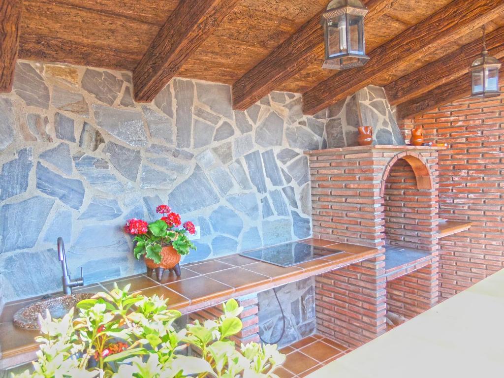 a stone kitchen with a sink and a brick wall at Villa Francisca in Málaga