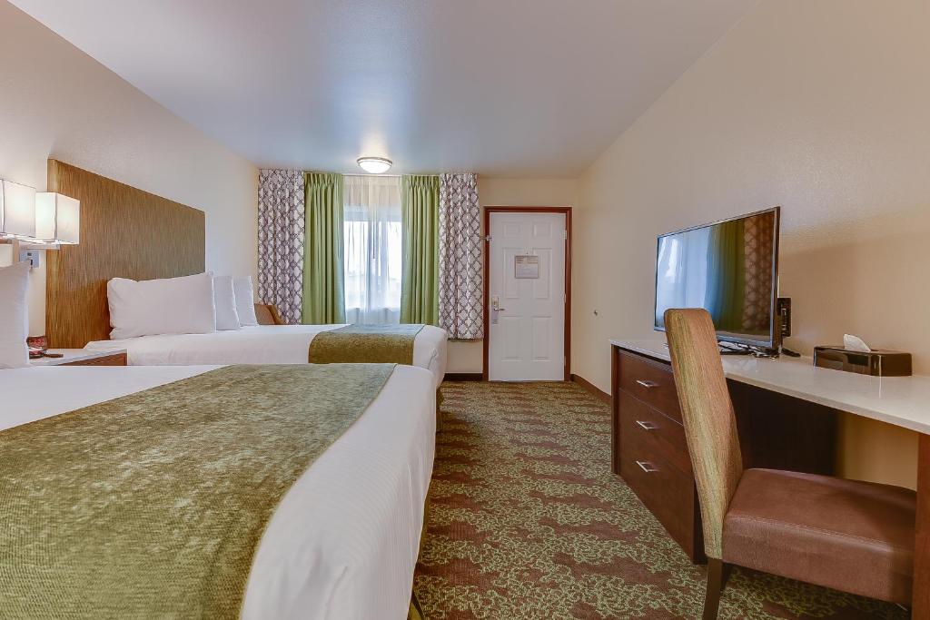 a hotel room with two beds and a flat screen tv at Vagabond Inn Bishop in Bishop