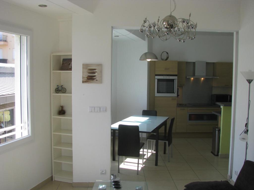 une salle à manger et une cuisine avec une table et des chaises dans l'établissement Le Peyron, à Saint-Raphaël