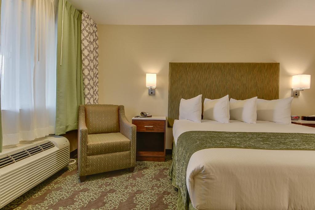 a hotel room with two beds and a chair at Vagabond Inn Bishop in Bishop
