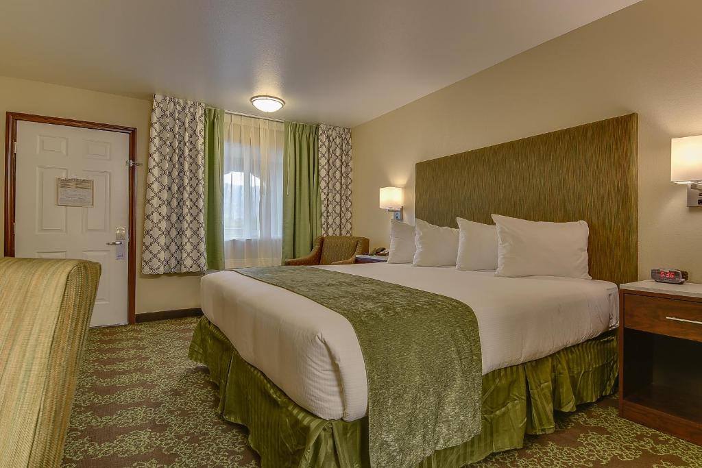 a hotel room with a large bed and a desk at Vagabond Inn Bishop in Bishop