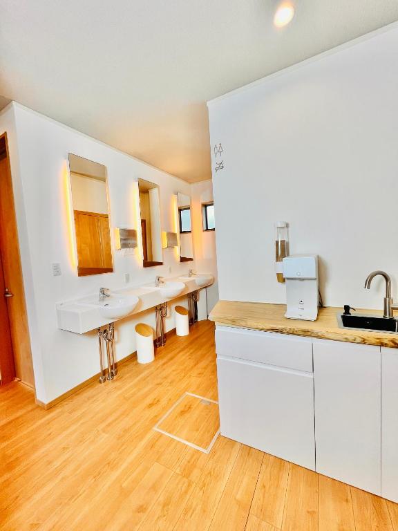 a bathroom with three sinks and a row of mirrors at hotel kusanagi in Nanao