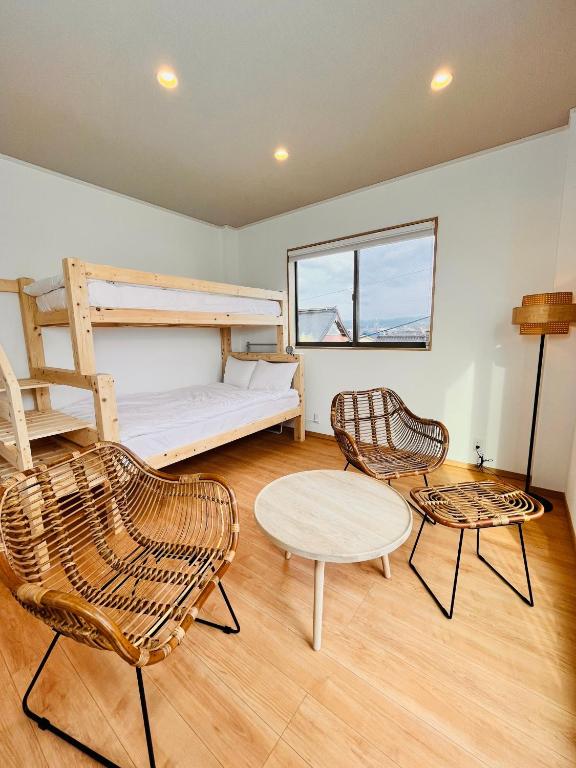 a room with a bunk bed and two chairs and a table at hotel kusanagi in Nanao