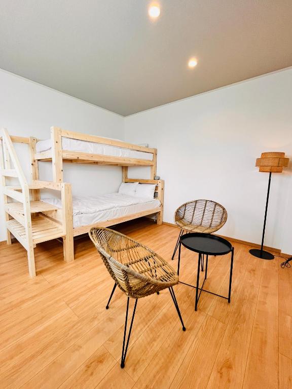 a room with a bed and two chairs and a table at hotel kusanagi in Nanao
