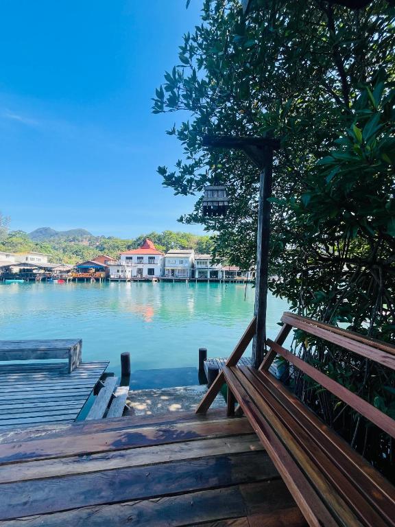 a bench sitting on a dock next to a body of water at River View House in Ko Chang