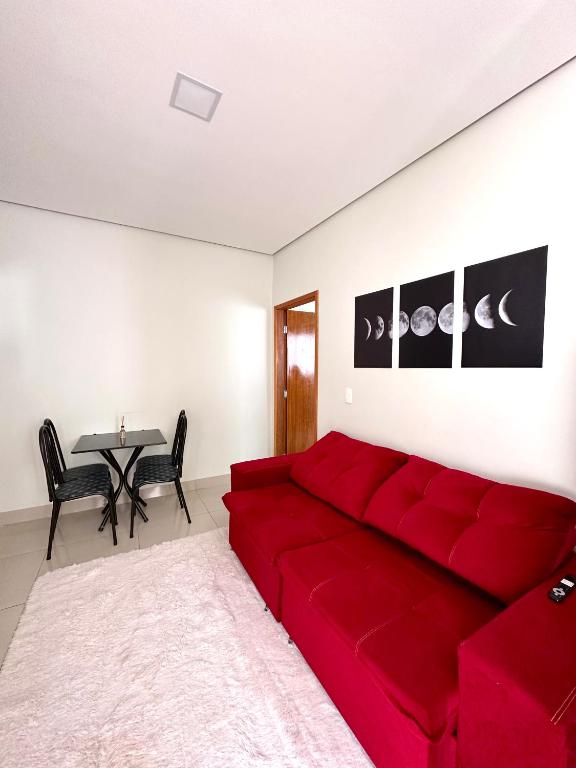 eine rote Couch in einem Wohnzimmer mit einem Tisch in der Unterkunft Casa Davisis - PX da JK e Centro - Ate 8 Hospedes in Palmas